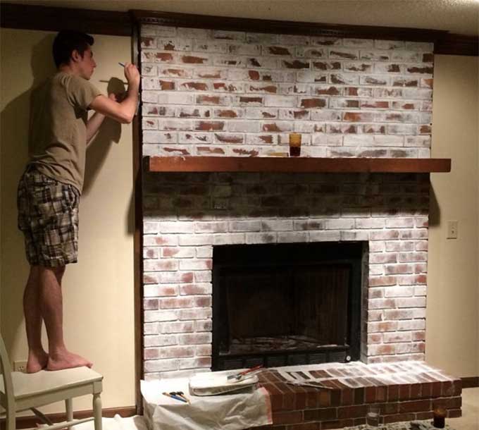 a person painting a brick fireplace